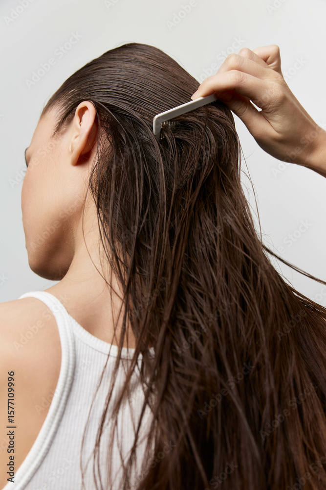 Obraz premium Hair care, grooming, beauty routine, woman combing wet hair, close up shot, natural hair texture, neutral background