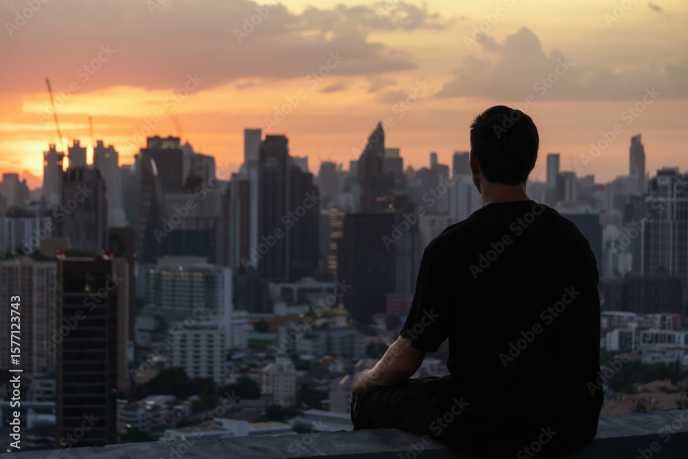 Fototapeta premium Outline of a man against sunset in Bangkok