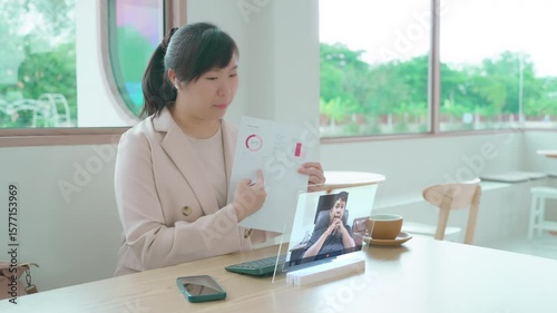 Businesswoman in a video conference using a futuristic transparent tablet to present a report. Concept of remote work, future technology, and online business communication.