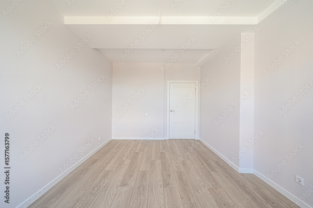 Obraz premium Bright, empty room with light wood floors, pale walls, white trim, and a white door. Minimalist interior, clean and ready for furnishing