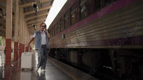 Asian older woman tourist travel luggage railway station platform journey destination adventure retirement explore summer holiday trip solo