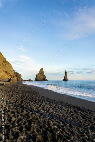 Reynisfjara is Iceland’s famous black sand beach with basalt columns, crashing Atlantic waves, and dramatic sea stacks.