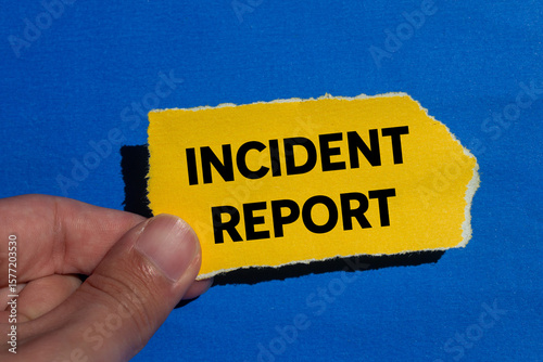 Tablou pe pânză Incident report message written on ripped torn yellow paper piece on blue background