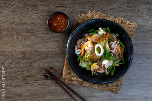 Foto fried  sukiyaki pork and seafood with vegetable and sukiyaki sauce, Thai street