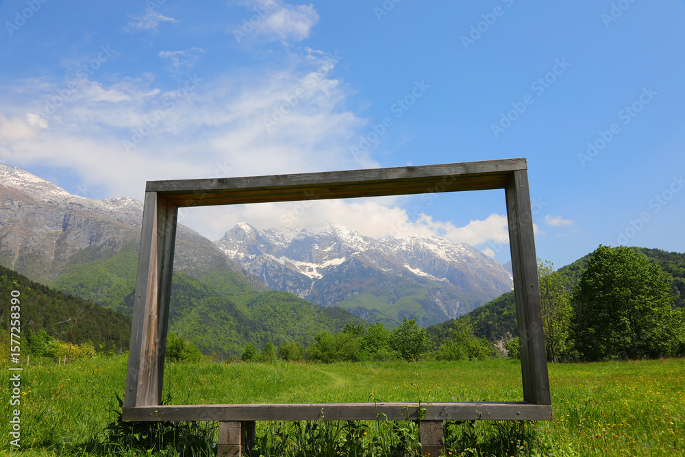 Fototapeta premium very big wooden frame and the European alps in background in Northern Italy