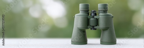 Green binoculars perched on a misty tabletop, whispering secrets of birdwatching adventures, World Migratory Bird Day exploration