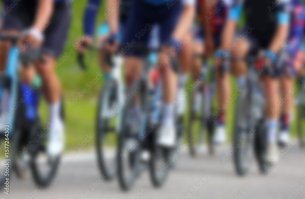 Naklejka premium Intentionally blurred group of many cyclists energetically pedaling their racing bikes during competitive road race