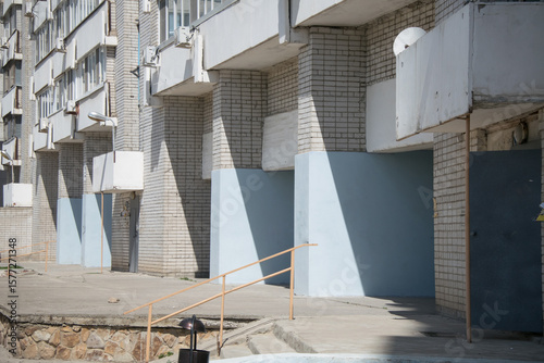 large brick blue plastered concrete arches on the ground floor of an apartment building