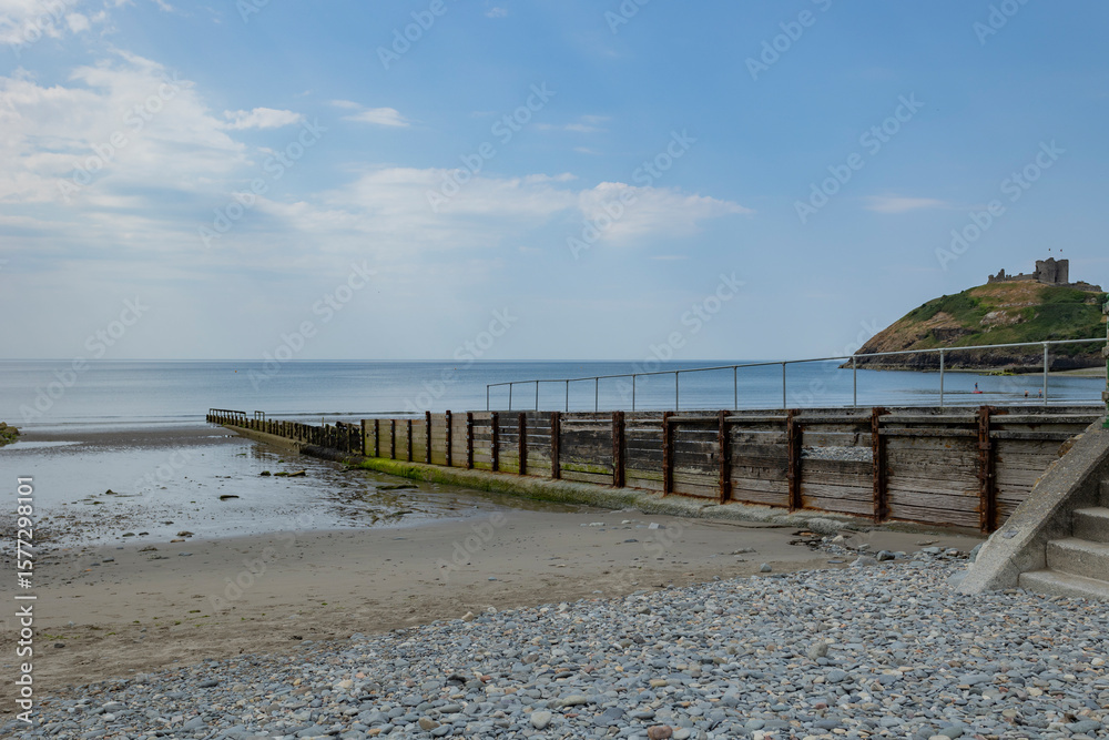 Fototapeta premium Wooden groynes stretching across a sandy beach