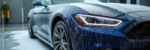 A sleek blue sports car being washed, showcasing its detailed design and dynamic features, perfect for automotive marketing and cleanliness promotion.