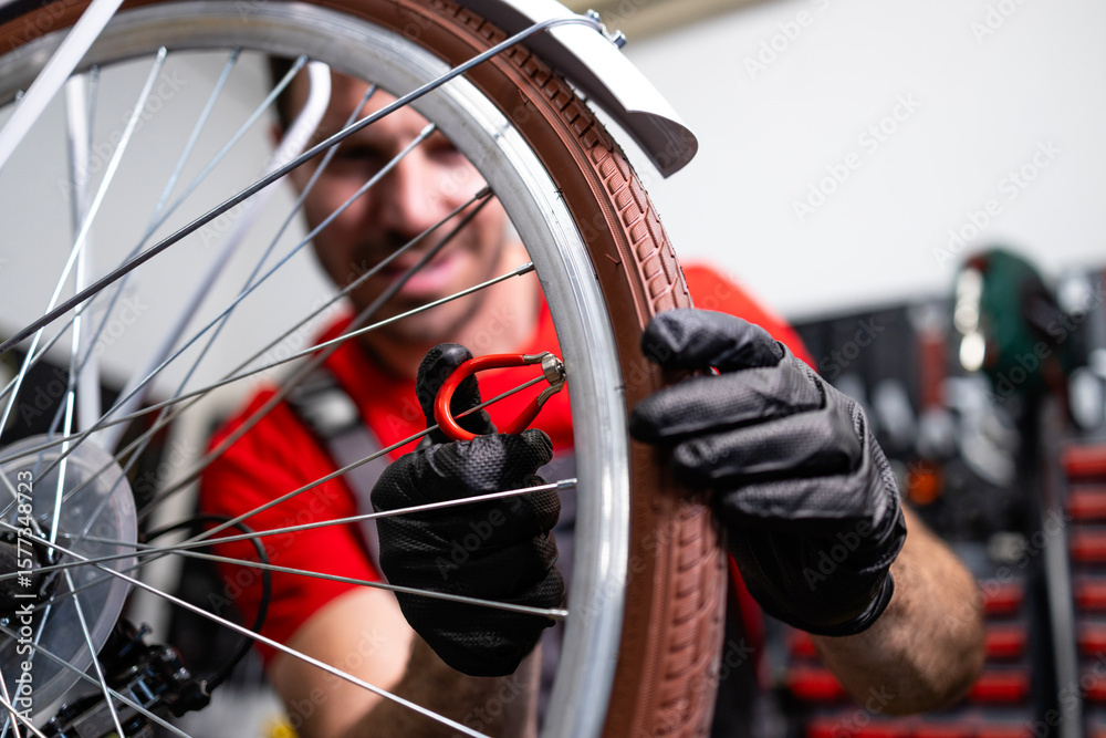 Fototapeta premium Professional experienced bicycle serviceman fixing wheel spokes.