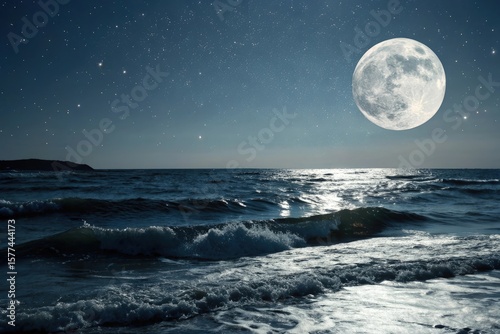 Full moon rising over ocean waves under starry night sky with dark shoreline and bright celestial light