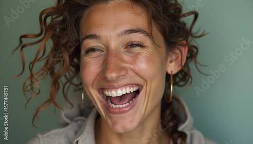 Authentic moment of pure joy captured as a young woman bursts into heartfelt laughter vibrant