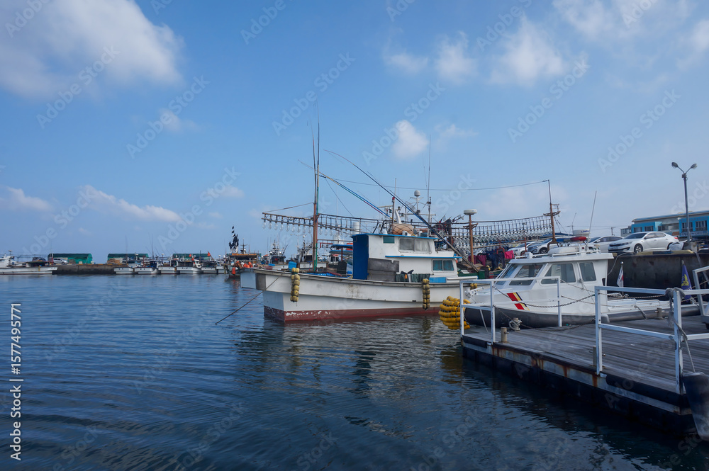 Fototapeta premium Fishing boats moored at a peaceful harbor under a clear summer sky
