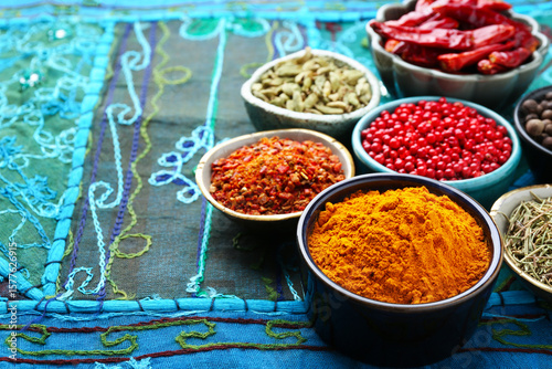 Fototapeta Naklejka Na Ścianę i Meble -  Many different aromatic spices in bowls on table with cloth, closeup. Space for text