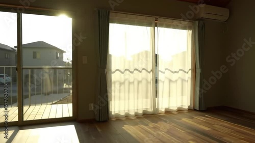 Interior view of a minimalist wooden cabin with sunlight casting long shadows, warm tones, and simple furnishings.