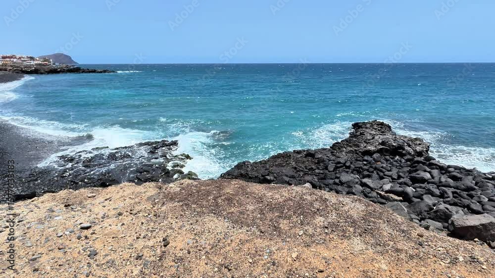 Stunning ocean landscape that showcases powerful waves crashing against a rocky shore beneath a clear blue sky Stunning ocean landscape that showcases powerful waves crashing against a rocky shore beneath a clear blue sky