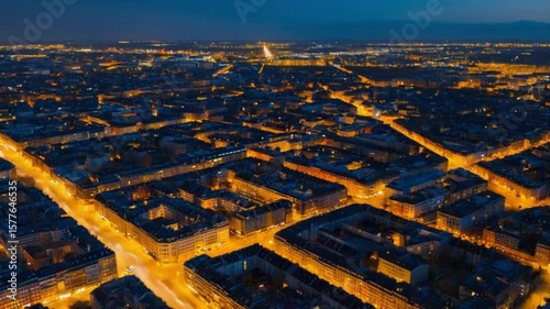 Aerial view of a vibrant cityscape at dusk, showcasing illuminated streets and buildings