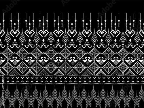 A detailed black and white geometric tribal pattern with symmetrical and intricate motifs, including arrows, diamonds, and hanging bead-like shapes.