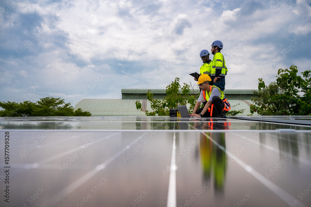 Obraz premium Group of photovoltaic engineer men working together inspecting solar panels on building roof