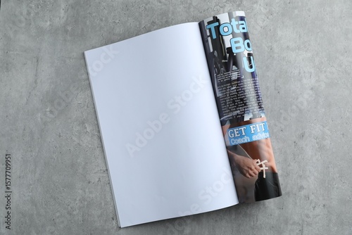 Open magazine on grey table, top view. Mockup for design