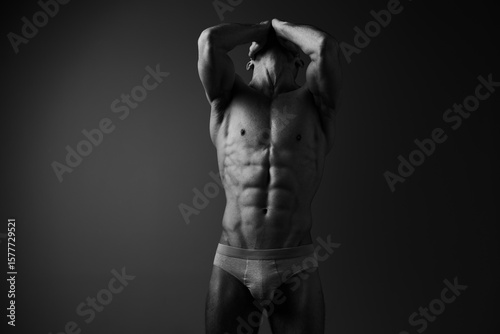 Принти на полотні Black and white image of a muscular man showcasing his toned physique, emphasizing strength, confidence, and fitness