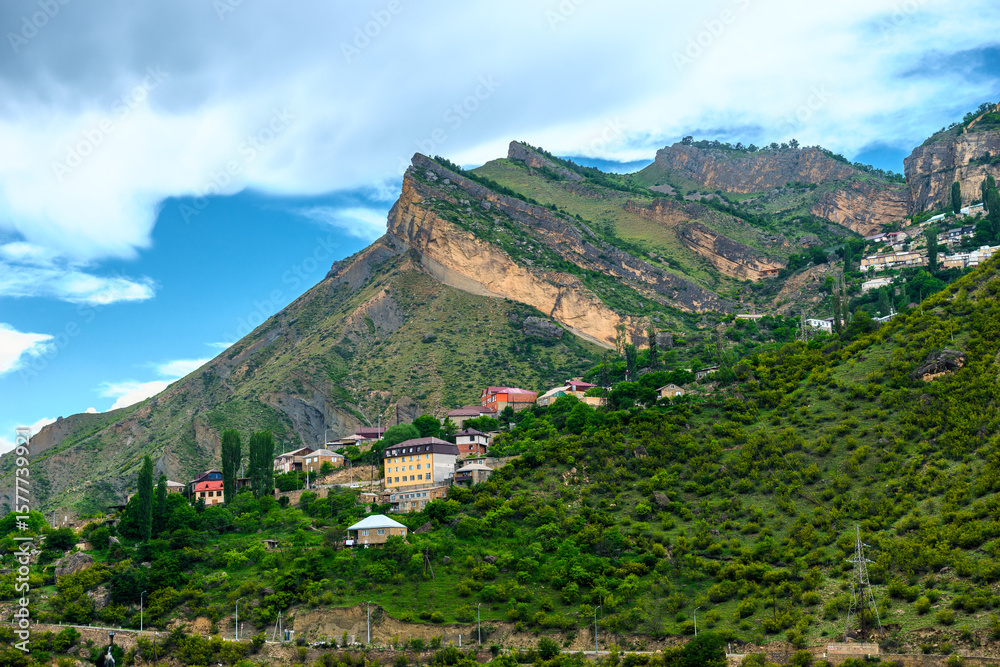 Fototapeta premium Beautiful landscape with rocky peak and mountain settlement in the mountains of the North Caucasus. Dagestan