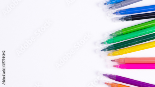 Foto Colorful markers for kids scattered on white background with copy space
