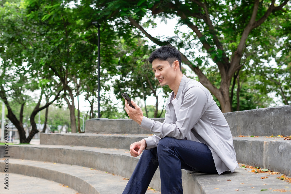 Obraz premium Young man uses mobile phone to communicate in public