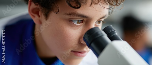 A young student using a microscope in a biology class, focused, exploration