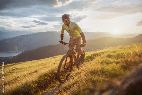 Cross Country Mountain Biker on Scenic Alpine Trail at Sunset