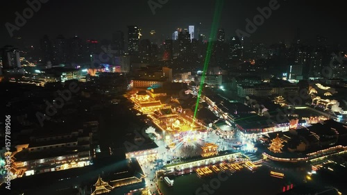 Wallpaper Mural Nanjing, China. Aerial view of a nighttime cityscape with illuminated buildings and a river reflecting the city lights. The city is bustling with activity. Torontodigital.ca