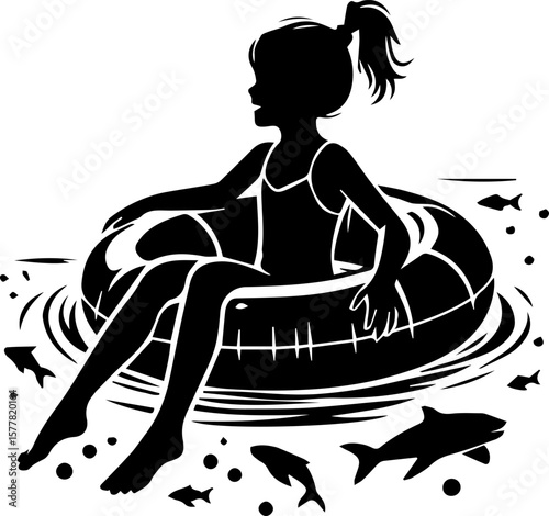Young girl sitting on inflatable inner tube in water with fish  