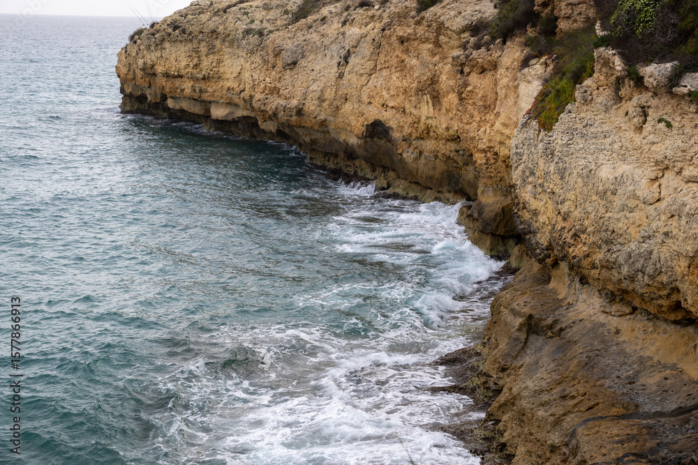 Obraz premium Stunning Torredembarra Lighthouse on rugged Mediterranean cliffs at Punta de la Galera, Tarragona, Catalonia. Perfect seaside nature and maritime beauty.