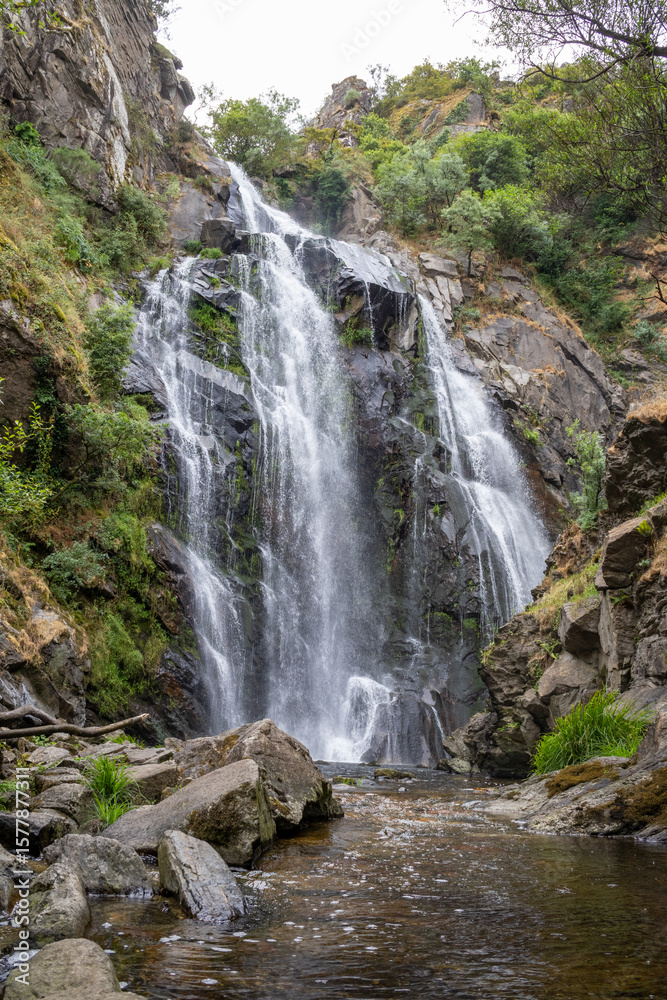 Fototapeta premium Fervenza do Toxa waterfall, a stunning 30m vertical drop in Silleda, Pontevedra, Galicia. Nature’s beauty captured in vibrant greenery and flowing water.