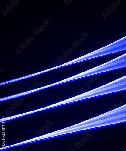 Three blue streaks of light converging on a black background