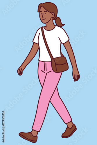 Dark skinned woman walks outside on hot day in smart outfit. Her confident stride and airy clothes reflect healthy habits
