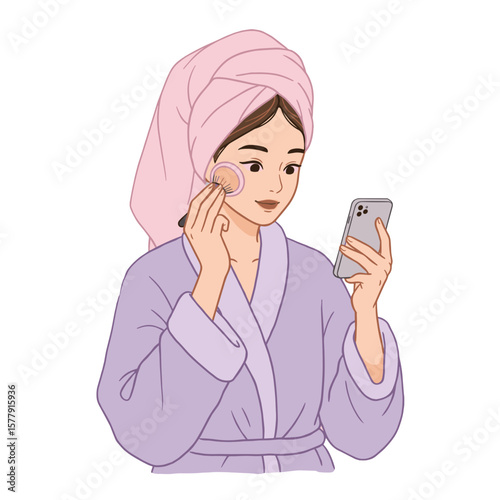 Woman in robe applying makeup while looking at her phone with a towel on her head in a white backdrop