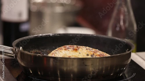 Pan-frying a delicious seasoned meat fillet in a hot skillet, gently basted by a chef. Perfect for culinary arts, recipes, home cooking, and professional kitchen content.