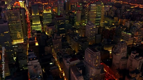 Aerial view of a sprawling city skyline illuminated by countless lights at dusk