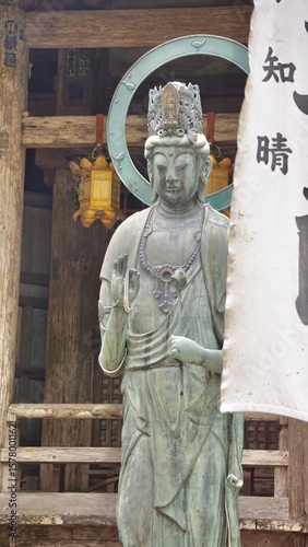 bronze goddess statue in front of a Japanese temple