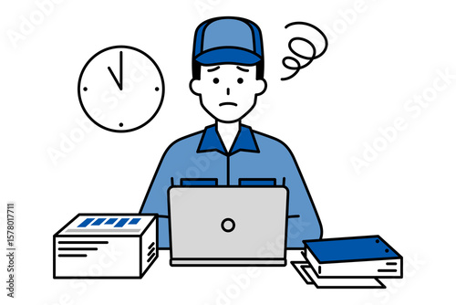 デスクワークの残業に困っているつなぎ作業服の男性