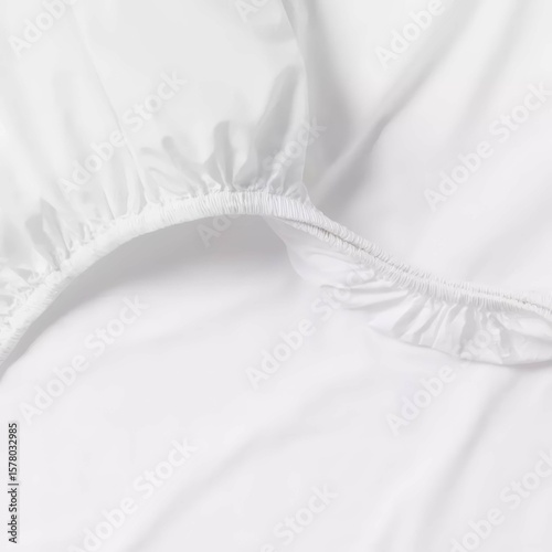 Soft white fitted sheet displayed on a bed, showcasing its smooth texture and elastic edges for a snug fit.