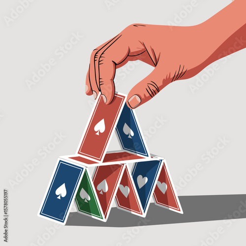 A hand carefully places a playing card atop a precarious house of cards structure.