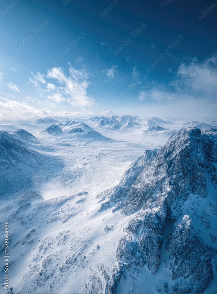 Fototapeta premium High-angle, winter mountain range. Snow-covered peaks and valleys under a vibrant blue sky