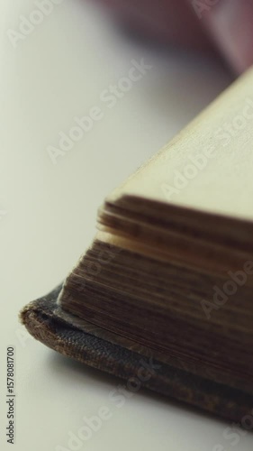 A Close-Up View Of Pages Being Turned In An Old Book, Highlighting The Textured Paper And Vintage Character. Vertical.
