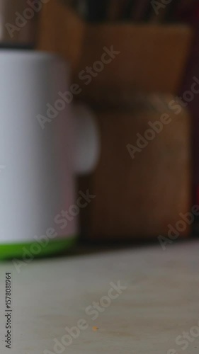 A Close-Up View Of A Hand Opening A Bottle Cap, Lifting The Bottle Off The Table, Returning It, And Closing The Cap, Highlighting Everyday Interaction. Vertical.