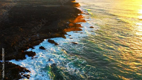 Experience the Stunning and Captivating Aerial View of Waves Crashing on the Rocky Shoreline