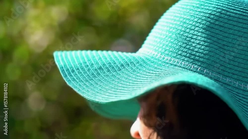 Teal sun hat in a leafy garden