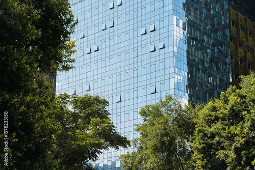 Modern office building exterior with green trees.